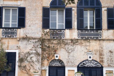 Mdina, Malta 'da yağmurlu bir günde mavi panjurlu ve kapısı olan beyaz bina.