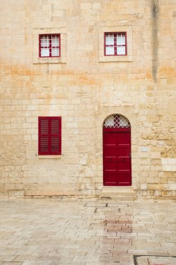 Mdina, Malta - 12 Ekim 2020: Yağmurlu bir günde Mdina, Malta 'da kırmızı kapısı ve penceresi olan beyaz binanın önü.