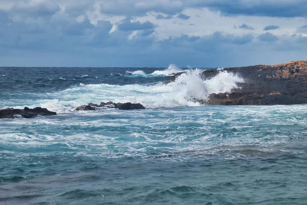 岩に対する波の衝突としてマルタのカワラで嵐の日の青い水と空 — ストック写真