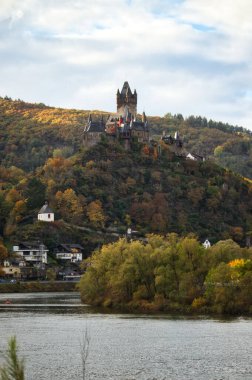 Reichsburg Cochem şatosu, Almanya 'nın Cochem kentinde Moselle nehri üzerindeki bir ağacın tepesinde..