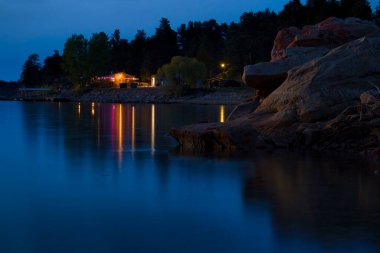 Keyhole State Park, Wyoming - 3 Haziran 2022 Wyoming 'de bir bahar akşamında Keyhole Gölü' ndeki suya yansıyan Marina ışıkları.
