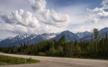 Alaska otoyolunun kenarındaki dağlar Tok yakınlarında bulutlu bir bahar günü. 