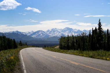 Richardson Karayolu 'nun arka planında dağlar var. Alaska' da güneşli bir bahar günü.. 