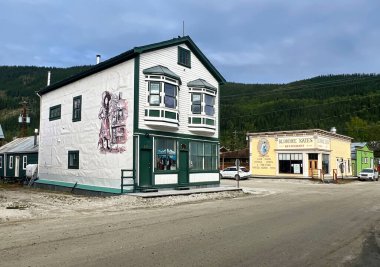 Dawson City, Kanada - 17 Ağustos 2024: Dawson City, Kanada 'da bulutlu bir yaz gününde bir sokak köşesinde bina.