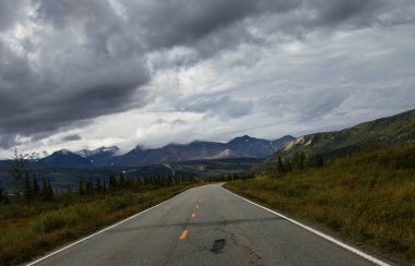 Alaska 'da bulutlu bir yaz gününde Denali otoyolunun arkasındaki dağlar. 