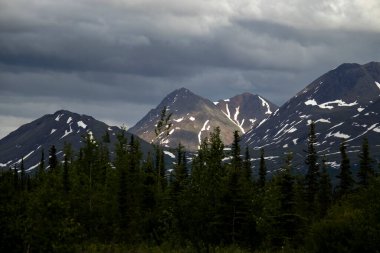 Alaska 'daki Denali Otoyolu' nda karanlık ve bulutlu bir yaz gecesinde, dağın zirvesinde parlayan ışık..