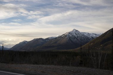 Kanada 'da bir sonbahar sabahı Alaska Otobanı' nda dağın tepesine vuran ışık.. 