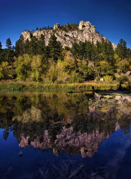 Güney Dakota 'da güneşli bir sonbahar gününde Spearfish Kanyonu' ndaki suda kayalık ve yansıma.
