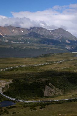 Tepeler ve dağlar bulutlu bir yaz gününde Richardson Karayolu yakınlarında Alaska 'nın iç kesimlerinde.