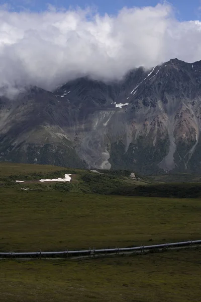 Alaska 'daki Richardson Otoyolu yakınlarındaki bir yaz gününde dağların üzerinden beyaz bulutlar..