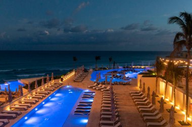 Cancun, Meksika - 11 Ocak 2026: Güneşin doğuşunda Meksika 'nın Cancun kentinde bir tatil köyünde havuz kenarındaki sandalyeler.
