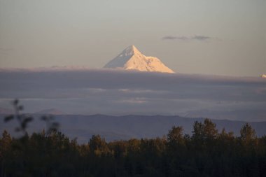 Delta Junction, Alaska yakınlarındaki bir yaz gecesinde, renkli bulutların üstündeki dağ zirvesi.