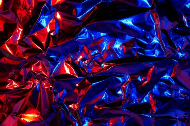 Soyut kırmızı ve mavi alüminyum kırışık folyo arka plan dokusu kırmızı ve mavi ışığı yansıtıyor