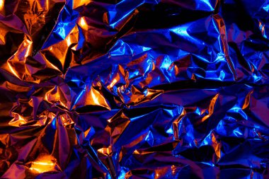 Soyut turuncu ve mavi alüminyum kırışık folyo arka plan dokusu kırmızı ve mavi ışığı yansıtıyor