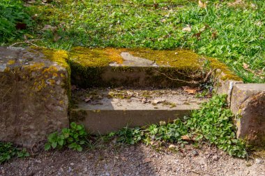 Eski kumtaşı adımları çimlere doğru gidiyor.