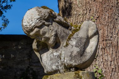 Eski ve hasarlı İsa heykeli yosunlarla kaplı.