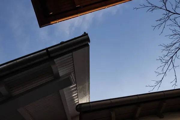 Low angle view of roof rain gutter against blue sky