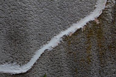 Çatallı beton duvar beyaz beton yama macunuyla onarılmış.