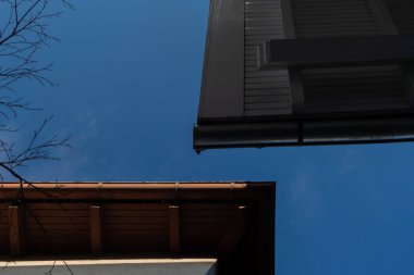 Mavi gökyüzüne karşı alçak açılı çatı yağmuru oluğu