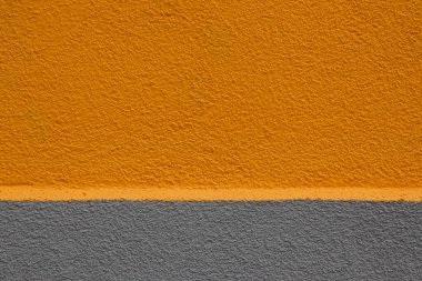 Üst üçte ikisi turuncuya boyanmış renkli duvar ve alt üçte biri griye boyanmış, kopyalanmış bir çıkıntıyla ayrılmış.