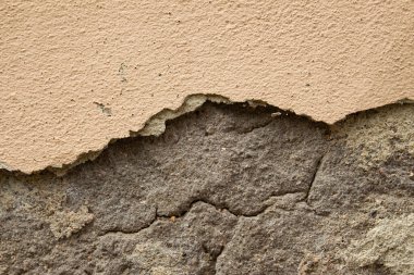 Eski, kirli, yıpranmış duvardan dökülen alçı tabakaları onarılmaya hazır.