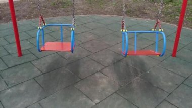 Anaokulunda çocuk parkında iki boş salıncak.