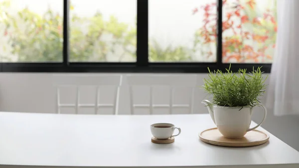 White coffee cup with plant pot don white dining table