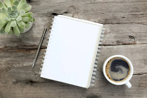 Kahve fincanı ve kaktüs tenceresi düz bir şekilde ahşap masanın üzerinde duruyordu.