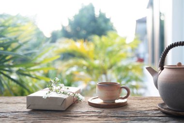 Kışın balkonda çiçekli çay takımı ve hediye kutusu.