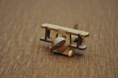 Tahtadan yapılmış küçük ahşap uçak modellerinin yaratıcı çekimlerini kapat. Boyutları yaklaşık 3 cm X 2 cm.