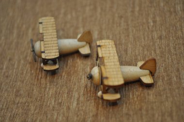 Tahtadan yapılmış küçük ahşap uçak modellerinin yaratıcı çekimlerini kapat. Boyutları yaklaşık 3 cm X 2 cm.