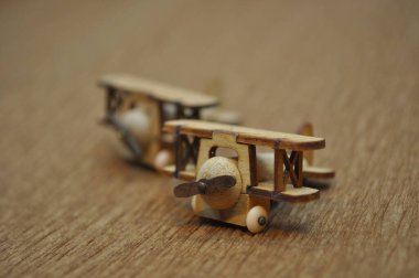 Tahtadan yapılmış küçük ahşap uçak modellerinin yaratıcı çekimlerini kapat. Boyutları yaklaşık 3 cm X 2 cm.