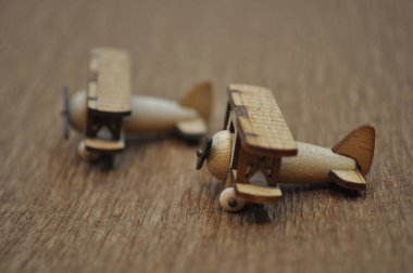 Tahtadan yapılmış küçük ahşap uçak modellerinin yaratıcı çekimlerini kapat. Boyutları yaklaşık 3 cm X 2 cm.