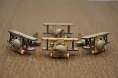 Tahtadan yapılmış küçük ahşap uçak modellerinin yaratıcı çekimlerini kapat. Boyutları yaklaşık 3 cm X 2 cm.