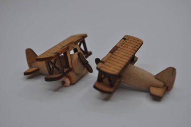Tahtadan yapılmış küçük ahşap uçak modellerinin yaratıcı çekimlerini kapat. Boyutları yaklaşık 3 cm X 2 cm.