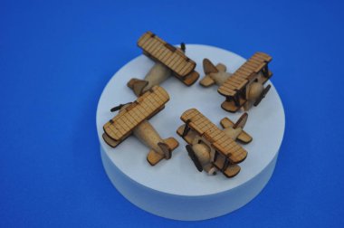 Tahtadan yapılmış küçük ahşap uçak modellerinin yaratıcı çekimlerini kapat. Boyutları yaklaşık 3 cm X 2 cm.
