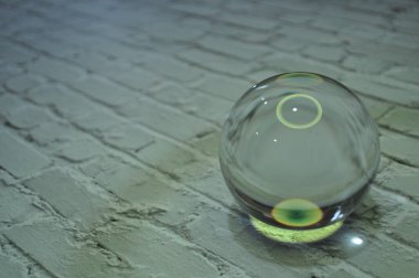 Parlak ışıklandırma ve lüks arka planı olan kristal cam küre.