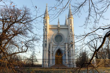 Pencereden çıplak ağaç dalları şeklinde gotik bir şapelin açılışı. Autumn Park 'ta. Mavi gökyüzü