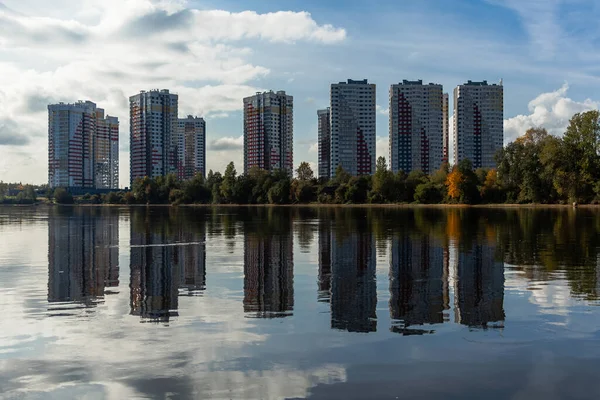 Reflection of Residential high-rise buildings in the river. Blue sky. Ripples in the water