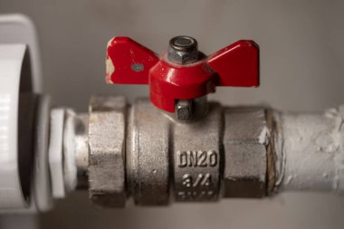 Kırmızı saplı radyatör vanası. Ev aküsünü ısıtmak için düzenleme yapılıyor. Ventel