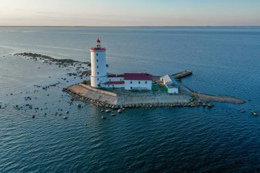 Tolbukhin deniz fenerinin panoramik hava manzarası. Finlandiya Körfezi 'ndeki yapay kayalık ada. En eski Rus deniz feneri. Baltık Denizi. Taşlı sahil. Yaz günü. Mavi gökyüzü