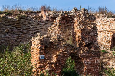 Penceresi ve kapısı olmayan, kırmızı tuğlalardan yapılmış eski bir harabe bina. Evin yıkılmış duvarları..