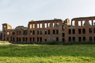 Penceresi ve kapısı olmayan, kırmızı tuğlalardan yapılmış eski bir harabe bina. Evin yıkılmış duvarları..