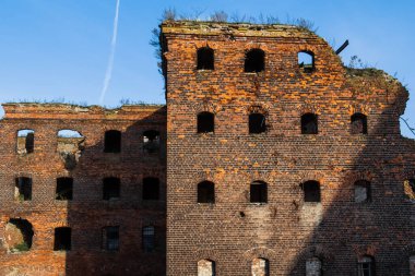 Penceresi ve kapısı olmayan, kırmızı tuğlalardan yapılmış eski bir harabe bina. Evin yıkılmış duvarları..