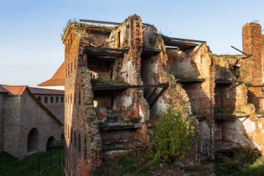 Penceresi ve kapısı olmayan, kırmızı tuğlalardan yapılmış eski bir harabe bina. Evin yıkılmış duvarları..