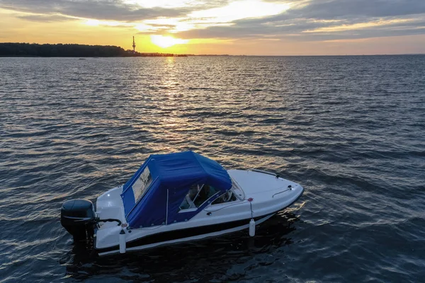 夏の日にフィンランド湾の沈む太陽に対する白い喜びのボート パワーボートだ 水の中の太陽のグレアの反射 — ストック写真