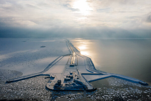Panoramic aerial view of the complex of protective structures of St. Petersburg against floods. Navigable passage. Dam. Ring road. Winter.