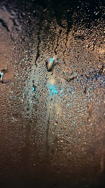Drops on car glass. Frosted glass. Night time
