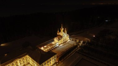 Büyük Saray 'ın yüksekliğinden ve kışın Peterhof' un üst bahçesinden panoramik bir manzara, ön cephe geceleri aydınlatılır. Müze. Rusya, Peterhof, 2.02.2020.