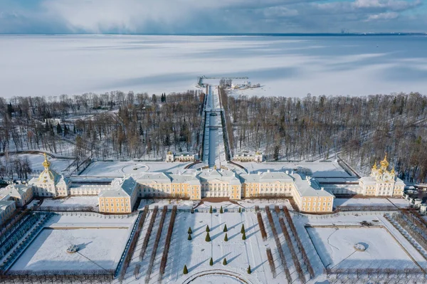 Büyük Saray 'ın panoramik hava manzarası ve Peterhof' ta kışın çeşmeli bir park. Üst bahçe restorasyon için kapalı, mavi gökyüzü, güneşli gün, beyaz kar. Rusya, Peterhof, 02.21.2021.